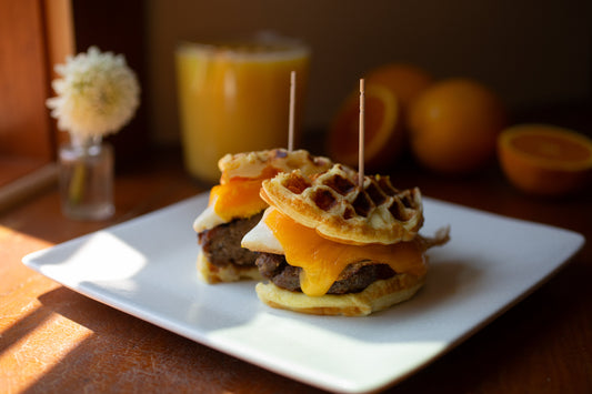 Sausage, egg, and cheese sandwich made with Heavenly Waffles as the bun, served hot and golden brown.